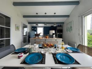 een keuken met een tafel met blauwe platen bij Villa de la Cible in Saint-Martin-de-Ré