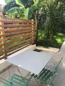 een witte tafel en stoelen naast een houten hek bij Studio independant dans maison basque in Bassussarry