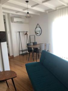 een woonkamer met een bank en een tafel en stoelen bij Studio independant dans maison basque in Bassussarry