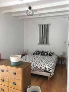 een slaapkamer met een bed en een houten dressoir bij Studio independant dans maison basque in Bassussarry