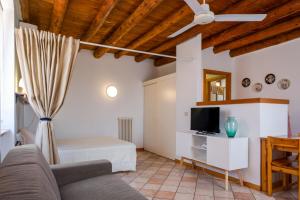een woonkamer met een bank en een tv bij Agriturismo Le Ginestre in Lazise