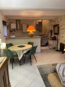 eine Küche und ein Esszimmer mit einem Tisch und Stühlen in der Unterkunft LE MAS D'ISACHRIS Le T2 in La Garde-Adhémar
