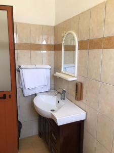 bagno con lavandino bianco e specchio di Vila Cano a Durrës