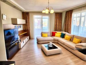 een woonkamer met een bank en een tv bij Durres Marina View Apartment in Durrës