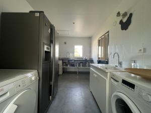 a kitchen with a dishwasher and a washer and dryer at Villa de la Cible in Saint-Martin-de-Ré