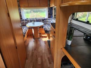 a kitchen and dining area of an rv at Ruime caravan op gezellige minicamping in Lichtenvoorde