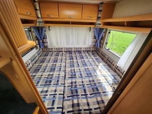 a view from the rear of a camper van with a checkered floor at Ruime caravan op gezellige minicamping in Lichtenvoorde
