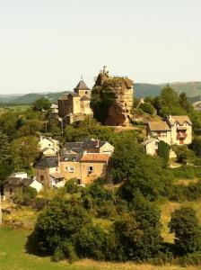 a small village with a castle on a hill at L’échappée belle, vue panoramique sur la campagne in Saint-Saturnin-de-Lenne