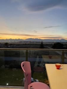 a table and a chair on a balcony with a sunset at Antalya Havalimanına Yakın Havuzlu 1+1 Lux Daire in Antalya