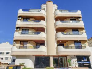 un edificio alto con balcones a un lado. en 299 - Excelente apto com 03 dormitórios, a 100m da praia de Bombas, en Bombinhas