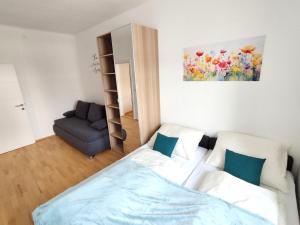 a bedroom with a bed and a couch and a painting at Ferienzimmer Reinisch in Tattendorf in Tattendorf
