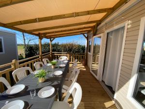 a patio with a table and chairs on a deck at Camping Ostréa **** in Dolus d'Oléron