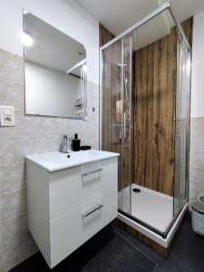 a bathroom with a white sink and a shower at Appartement à 150 m de la cathédrale in Rodez
