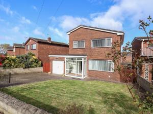 a brick house with a garage and a yard at 107 Gronant Road in Prestatyn