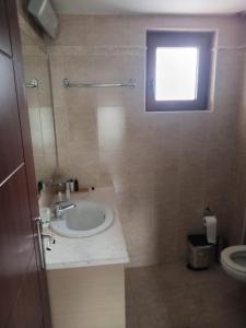 łazienka z umywalką, toaletą i oknem w obiekcie Gasparakis Villas w mieście Plakias
