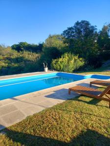 - une piscine avec un banc en bois à côté dans l'établissement MIRADOR DEL LAGO - La Vista, à Villa Parque Siquiman