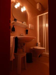 a bathroom with a sink and a toilet and a mirror at Garni Unterwegguetl in Naturno