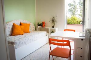 um quarto com uma cama com almofadas laranja e uma secretária em Iscairia Country House em Ascea