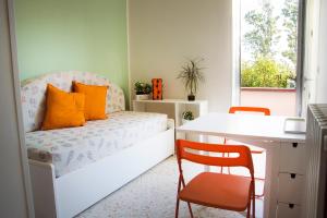 1 dormitorio con cama con almohadas de color naranja y escritorio en Iscairia Country House, en Ascea