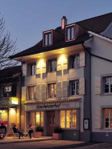 a large white building with people sitting outside of it at Röschenzerhof in Röschenz