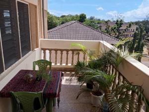 a balcony with a bench and a table and plants at Samia House in Malindi