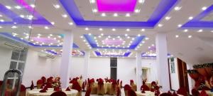 Cette chambre est dotée de tables, de chaises et d'un plafond violet. dans l'établissement Avanya Hotel And Reception Hall, à Angunakolapelessa