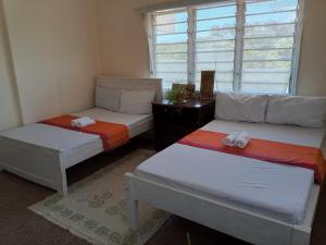 two twin beds in a room with a window at Samia House in Malindi