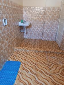 a bathroom with a tiger patterned floor and a sink at Samia House in Malindi