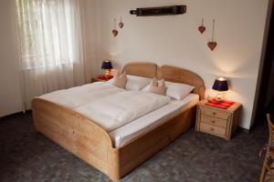 a bed in a bedroom with two night stands and two lamps at Garni Unterwegguetl in Naturno