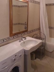 part of the house is available for short-term rentals in Sorrento center في سورينتو: حمام مع مغسلة وغسالة ملابس