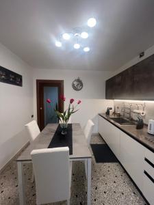 a kitchen with a table with a vase of flowers on it at Ca' Delfina Holiday Home in Venice