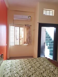 een slaapkamer met een bed en een raam bij Anand Yatri Grah, Ujjain in Ujjain