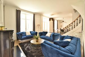 Hôtel particulier Le Trémolières في شوليه: غرفة معيشة مع أرائك زرقاء وطاولة