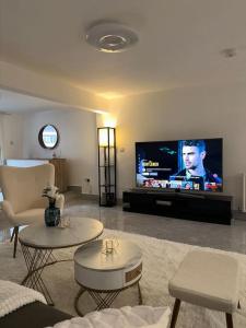 uma sala de estar com duas mesas e uma televisão de ecrã plano em Central entire studio apartment em Londres