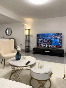 Central entire studio apartment في لندن: غرفة معيشة مع تلفزيون وأريكة وطاولة