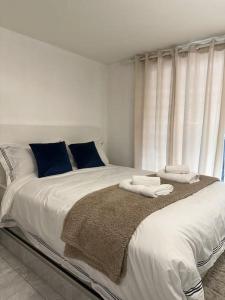 a bedroom with a large white bed with towels on it at Central entire studio apartment in London