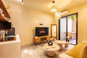 Sala de estar con 2 mesas y TV en Suite de luxe + jacuzzi à Gueliz, en Marrakech