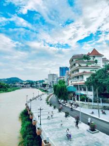 a group of people walking on a sidewalk next to a river at Liu homestay in Nà Phia