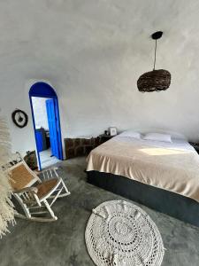 a bedroom with a bed and a chair and a blue door at Bahareque glamping in Barichara