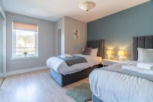 a bedroom with two beds and a window at Penthouse at the Bay near Edinburgh in Saint Davids