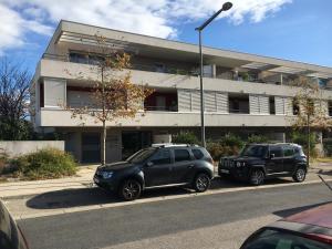 dois carros estacionados em frente a um edifício em Appartement T2 à 10 min de Montpellier em Vendargues