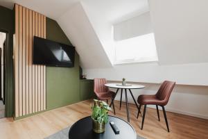 a living room with a table and a tv on a wall at Lamara Flat 3, Liverpool in Liverpool