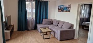 a living room with a couch and a table at Central apartment with city view in Braşov