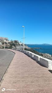 a road next to the ocean with a street light at Chalet de la playa in Oropesa del Mar
