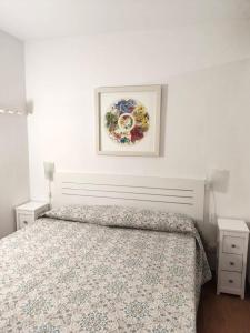 een slaapkamer met een bed en een schilderij aan de muur bij Voramar D- Estudi in Calella de Palafrugell
