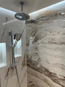 un baño con una pared de piedra y una lámpara. en Arletti Luxury Living Apartment en Ruse