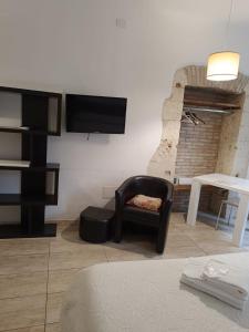 sala de estar con silla y TV en la pared en AL183, en Cagliari