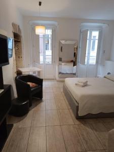 a bedroom with a bed and a chair and a television at AL183 in Cagliari