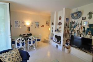 a living room with a table and a television at Villaggio Estate in Lignano Sabbiadoro