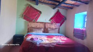 a bedroom with a bed with pink sheets and a window at Gîte Forest Tagroumte in Azrou